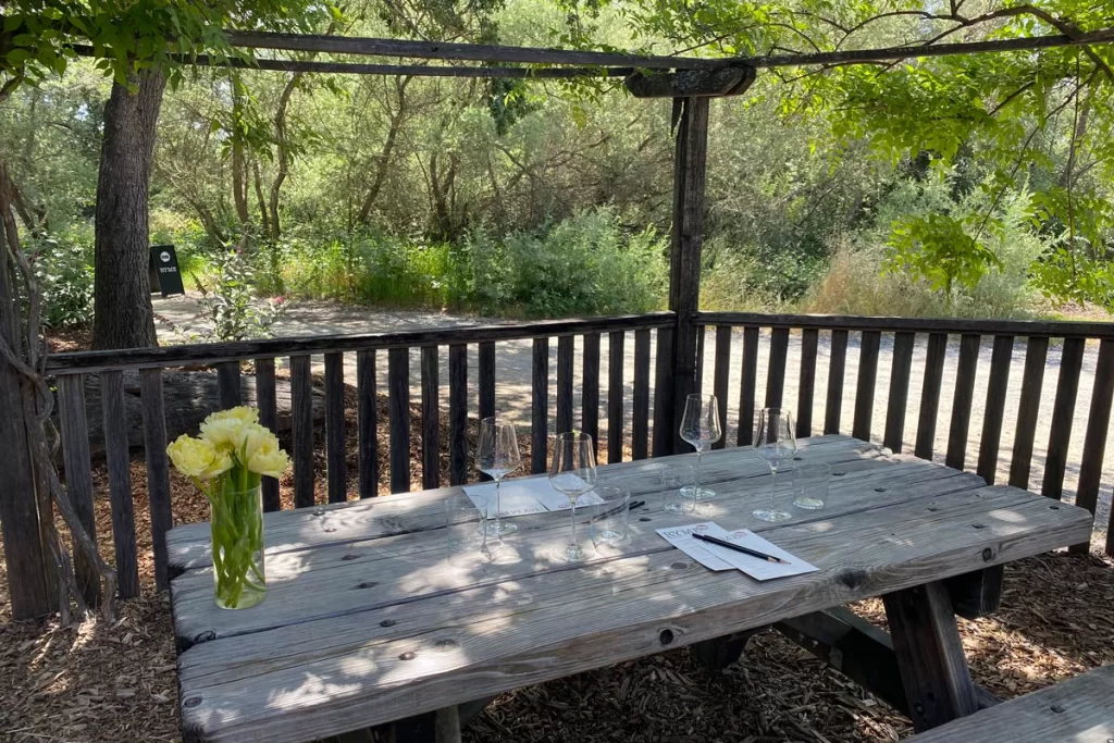 A wooden picnic table is laid out for a wine tasting at Ryme Cellars in Forestville, California. Ryme is known for all natural Sonoma wine.