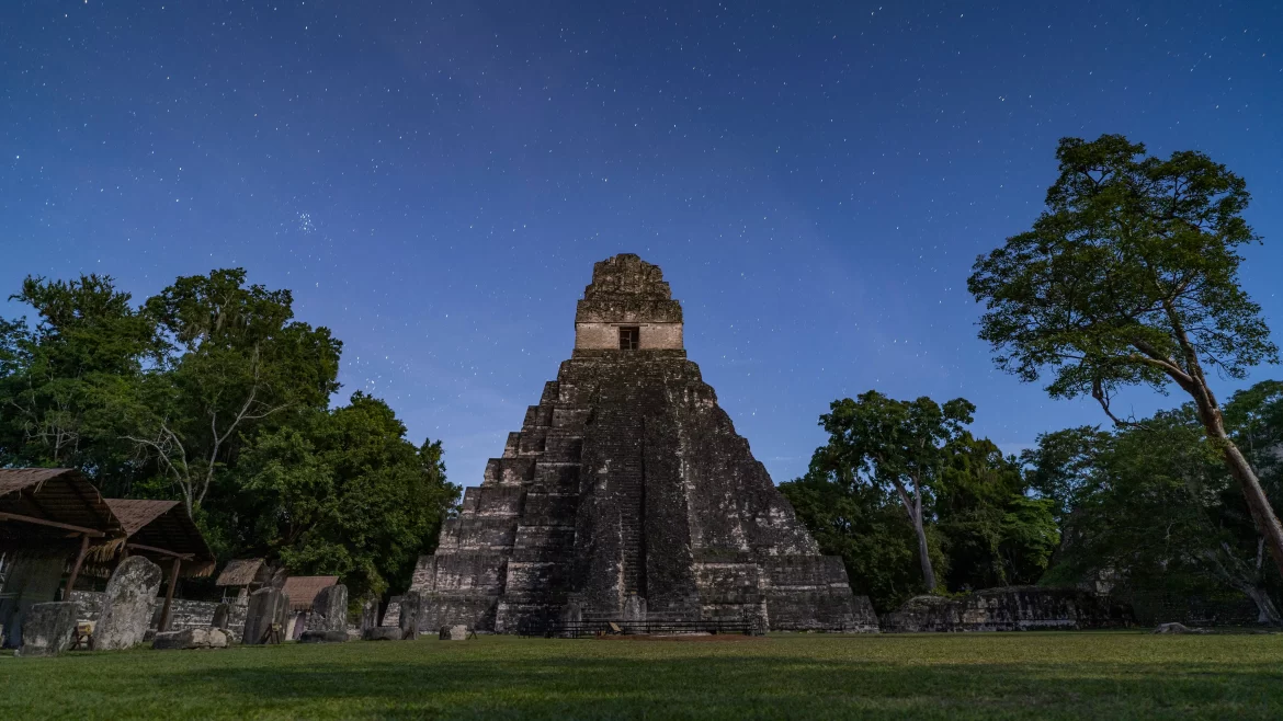 Tikal's Temple of the Great Jaguar, one of the most famous Mayan pyramids, stands tall against a dusk sky.